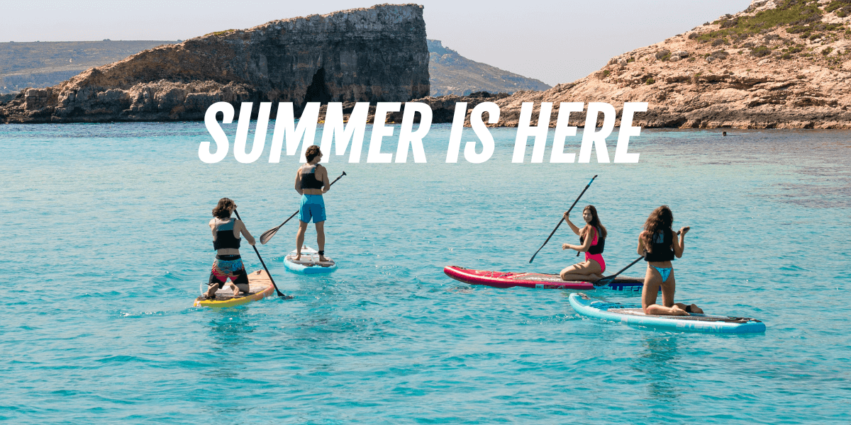 four people paddling out to the ocean having fun