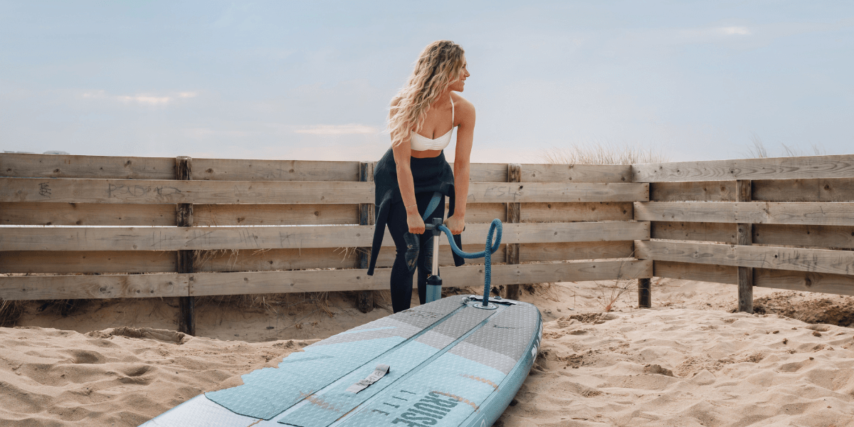 woman pumping up a paddleboard
