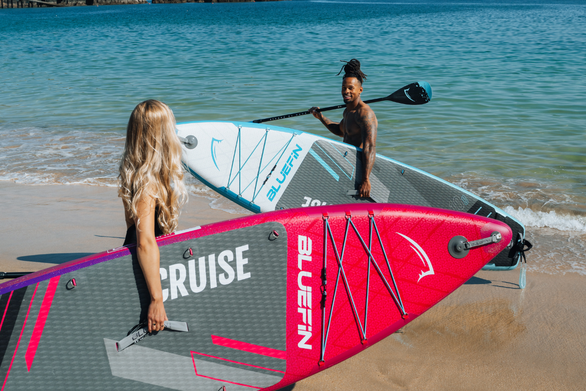 four people paddleboarding on bluefin cruise boards out in the ocean