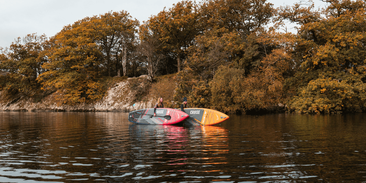 two people holding paddleboards in water