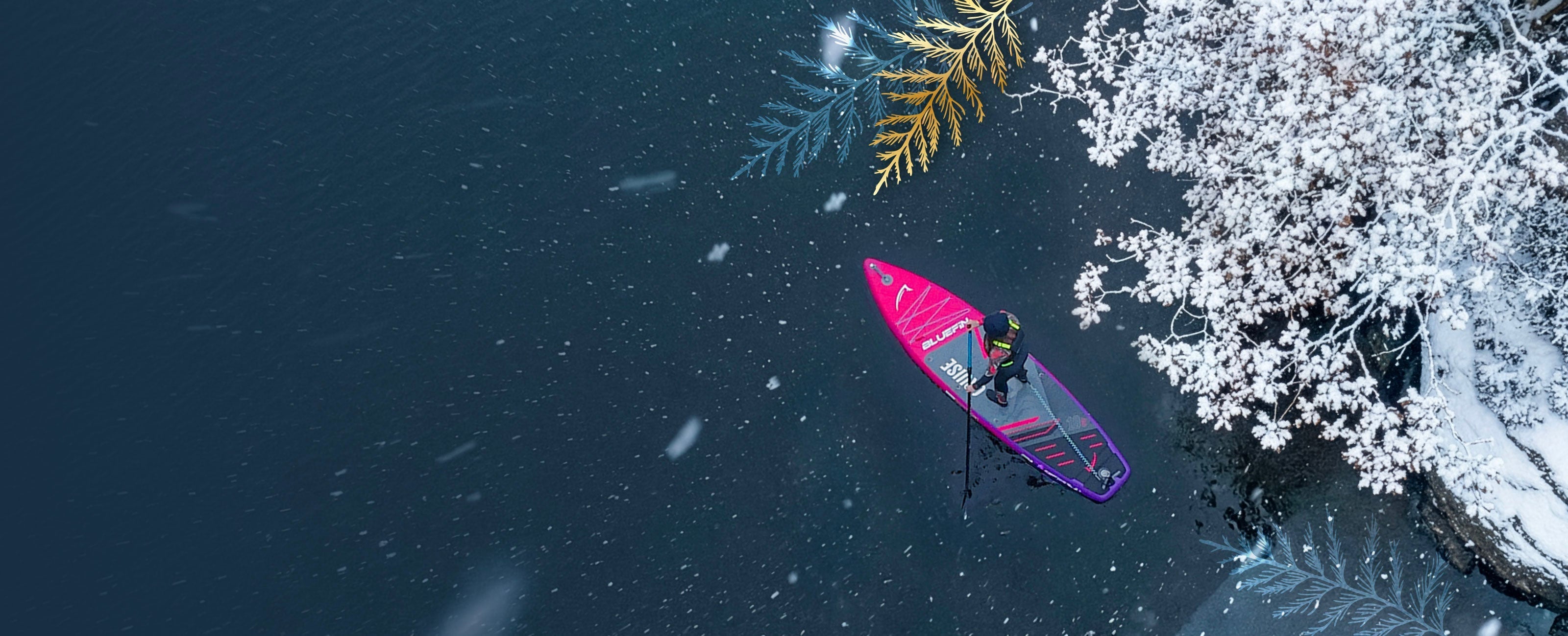 Woman paddleboarding on a lake with snow coming down