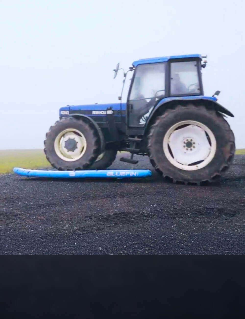 Tractor driving over inflatable Bluefin sup