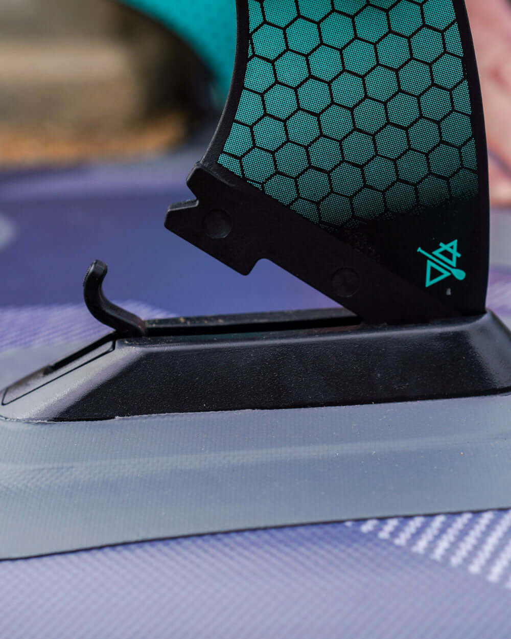 close up of someone attaching a bluefin smartlock fin to an inflatable sup