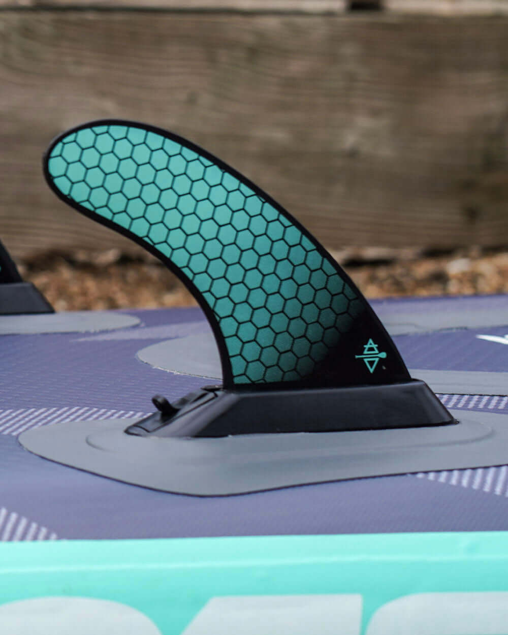 Close-up of a paddleboard fin with a honeycomb pattern on a blurred background
