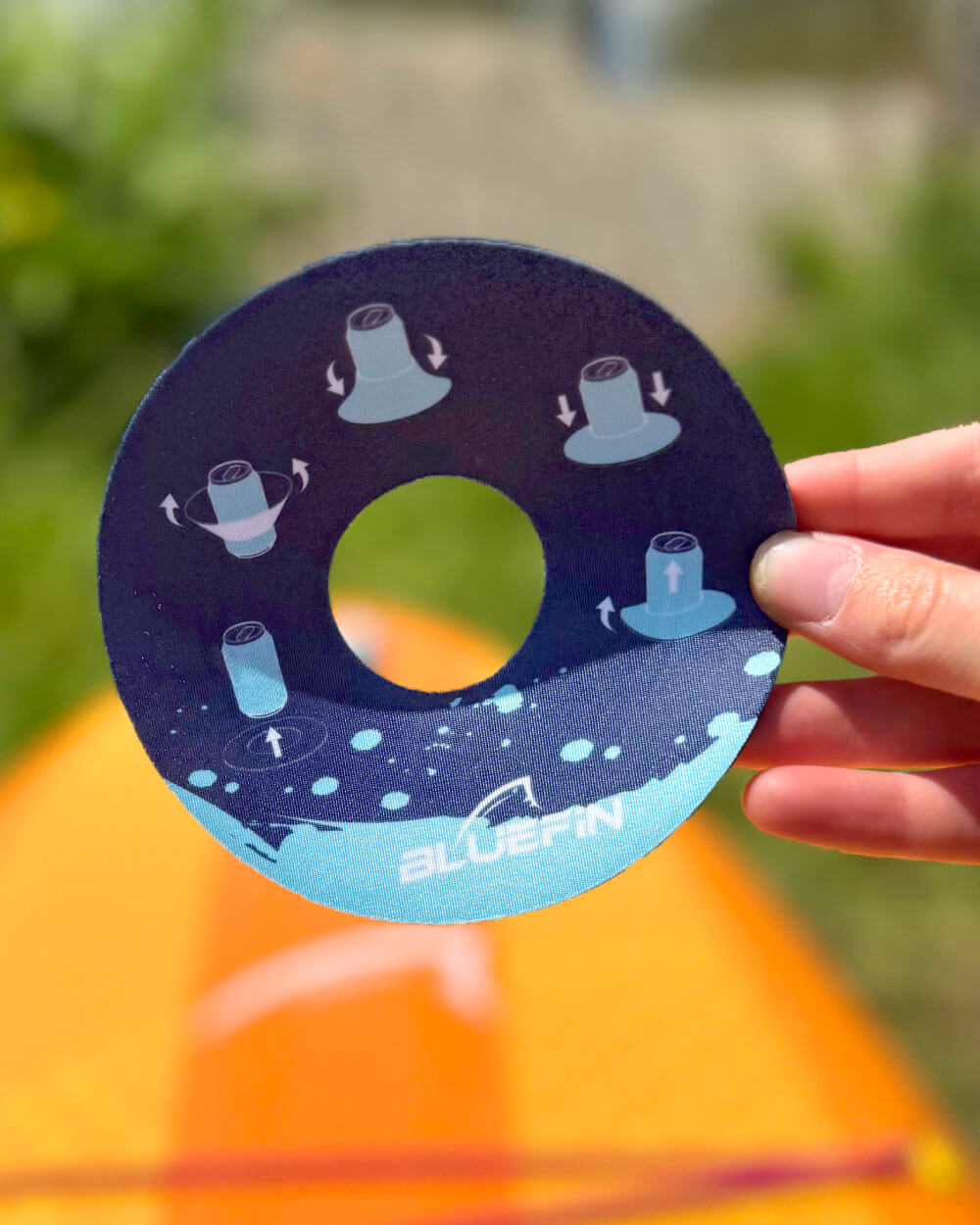 Bluefin bottle dock with 'BLUEFIN' branding held by a hand outdoors.