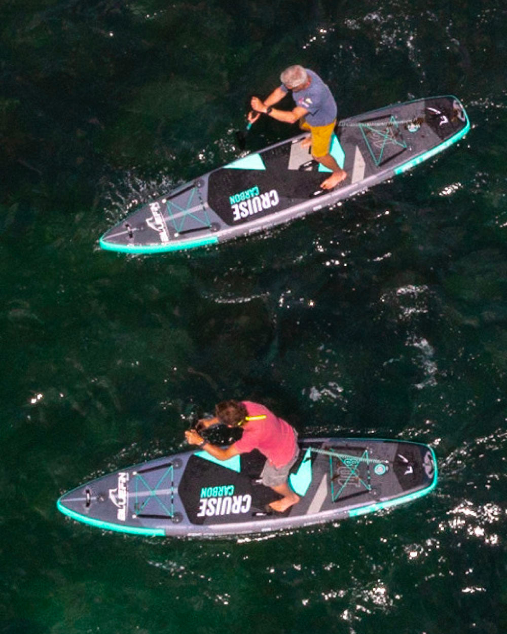 Two people on cruise carbon stand-up paddleboards in the water