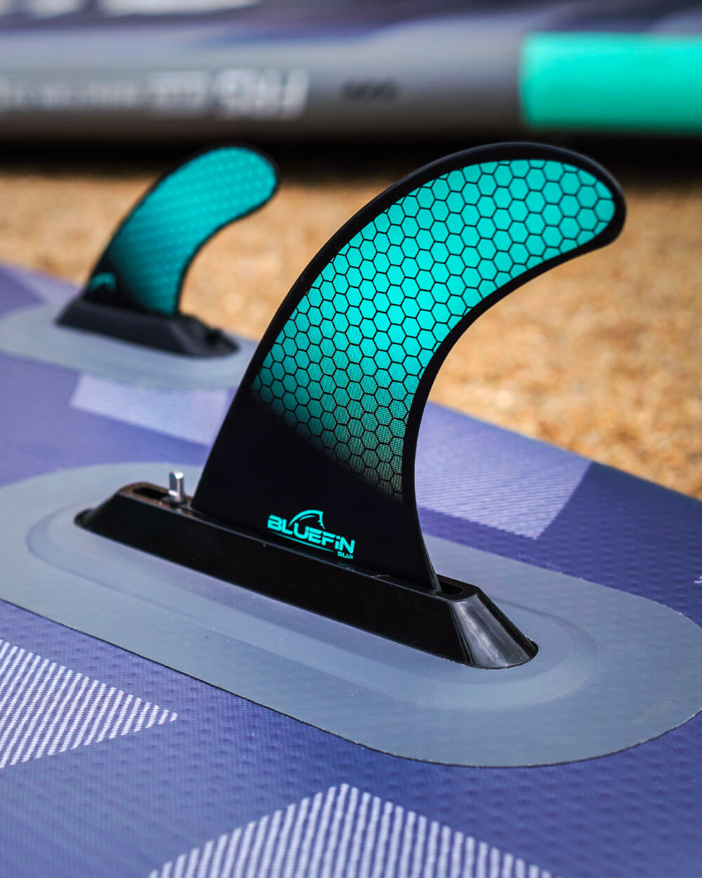 Close-up of a fin with 'Bluefin' branding on a inflatable stand up paddle board