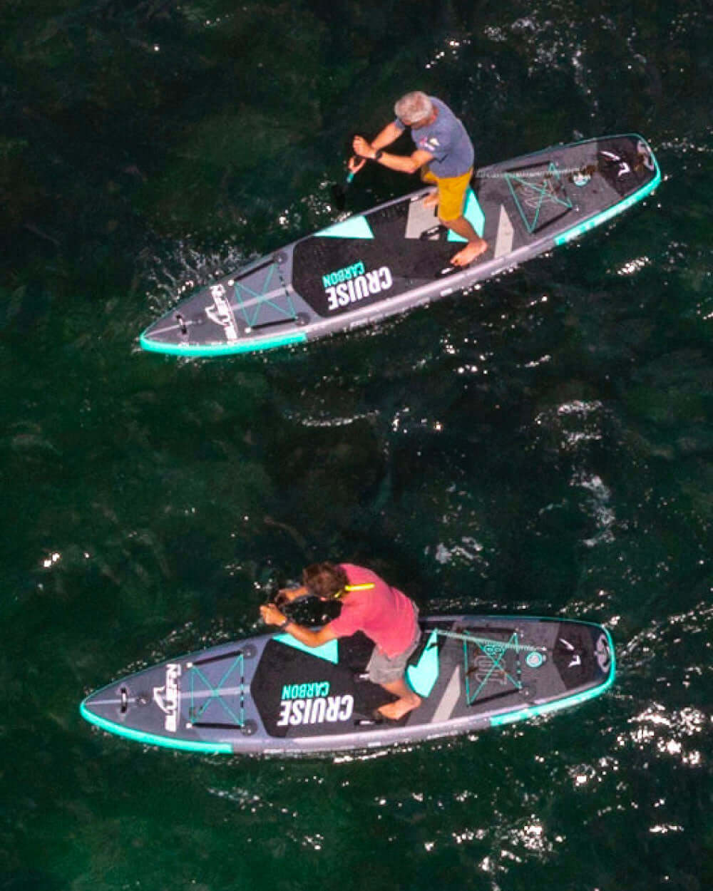Two people on Cruise Carbon stand-up paddleboards in the water