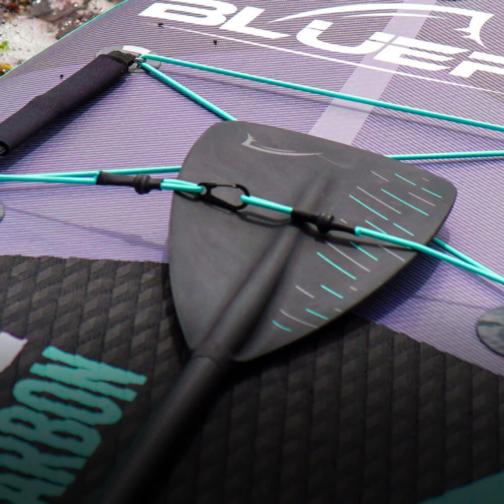 Close-up of a Bluefin SUP paddle on a textured board surface. Features vibrant blue accents and a sleek design.
