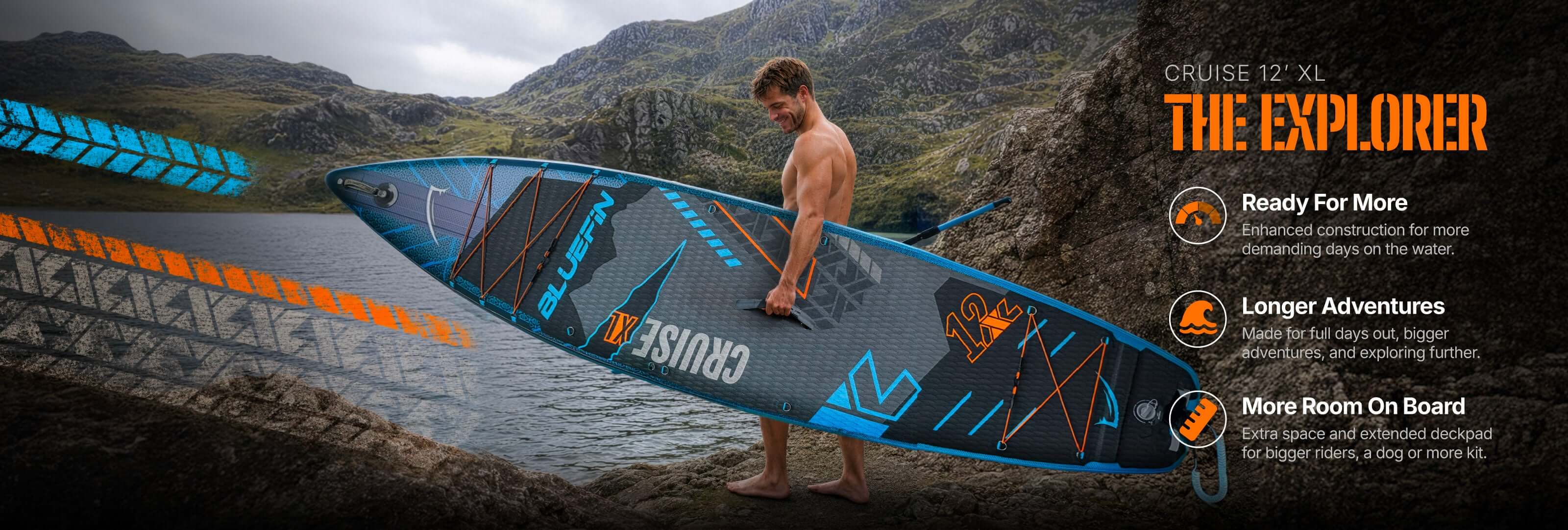 Inflatable paddleboard with textured deck, center fin, and orange and blue accents in a scenic outdoor setting