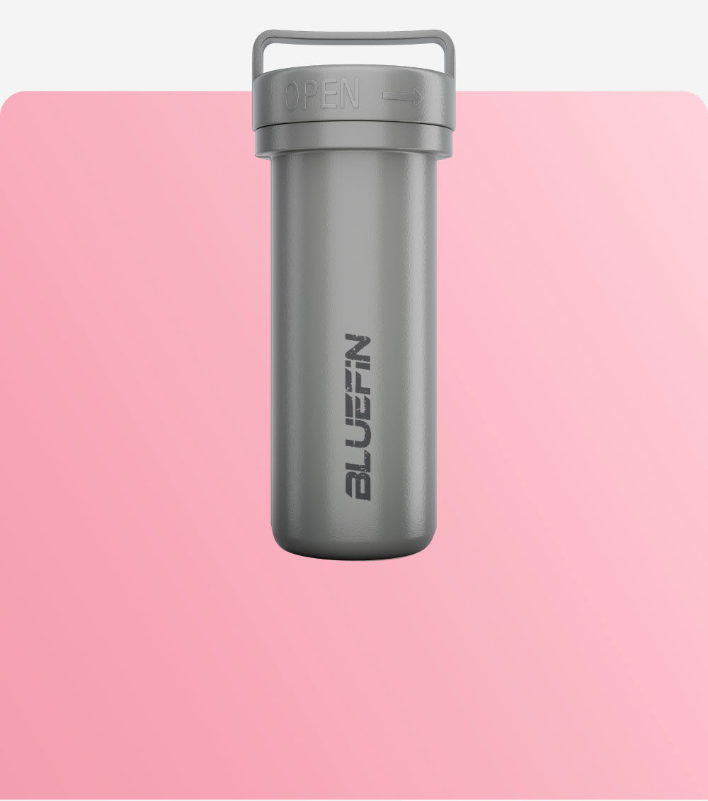 Gray waterproof dry bag with an open/close feature, featuring the Bluefin logo, against a pink background.