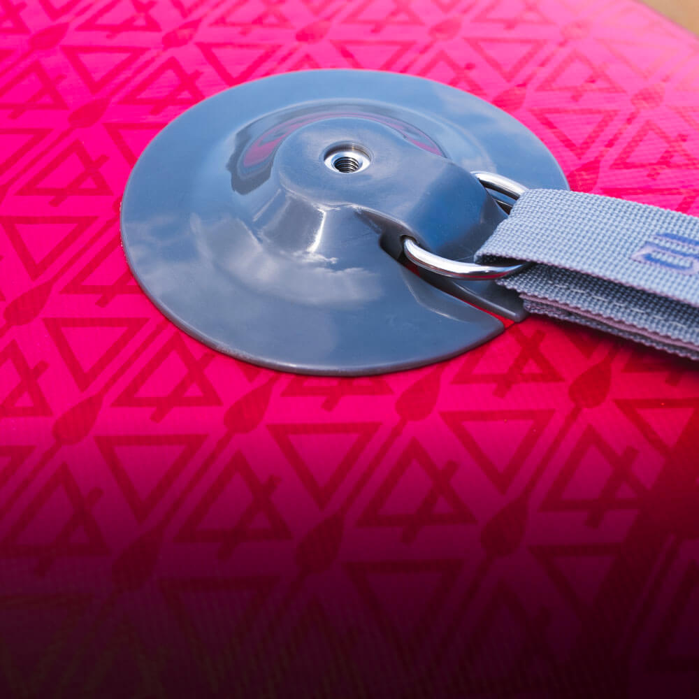 Close-up of a pink SUP surface showing a gray attachment buckle and strap. Ideal for paddleboard enthusiasts.