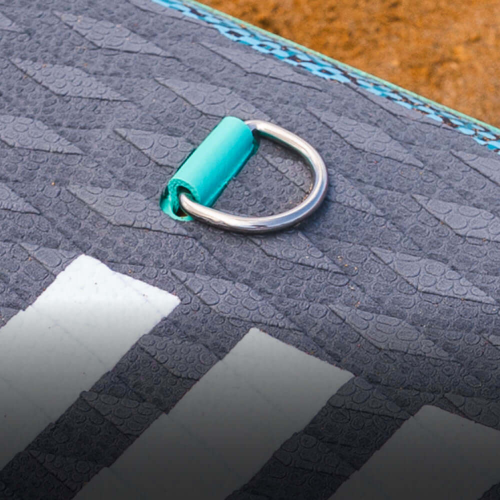 Close-up of a textured stand-up paddleboard with a blue clip and metal D-ring detail.