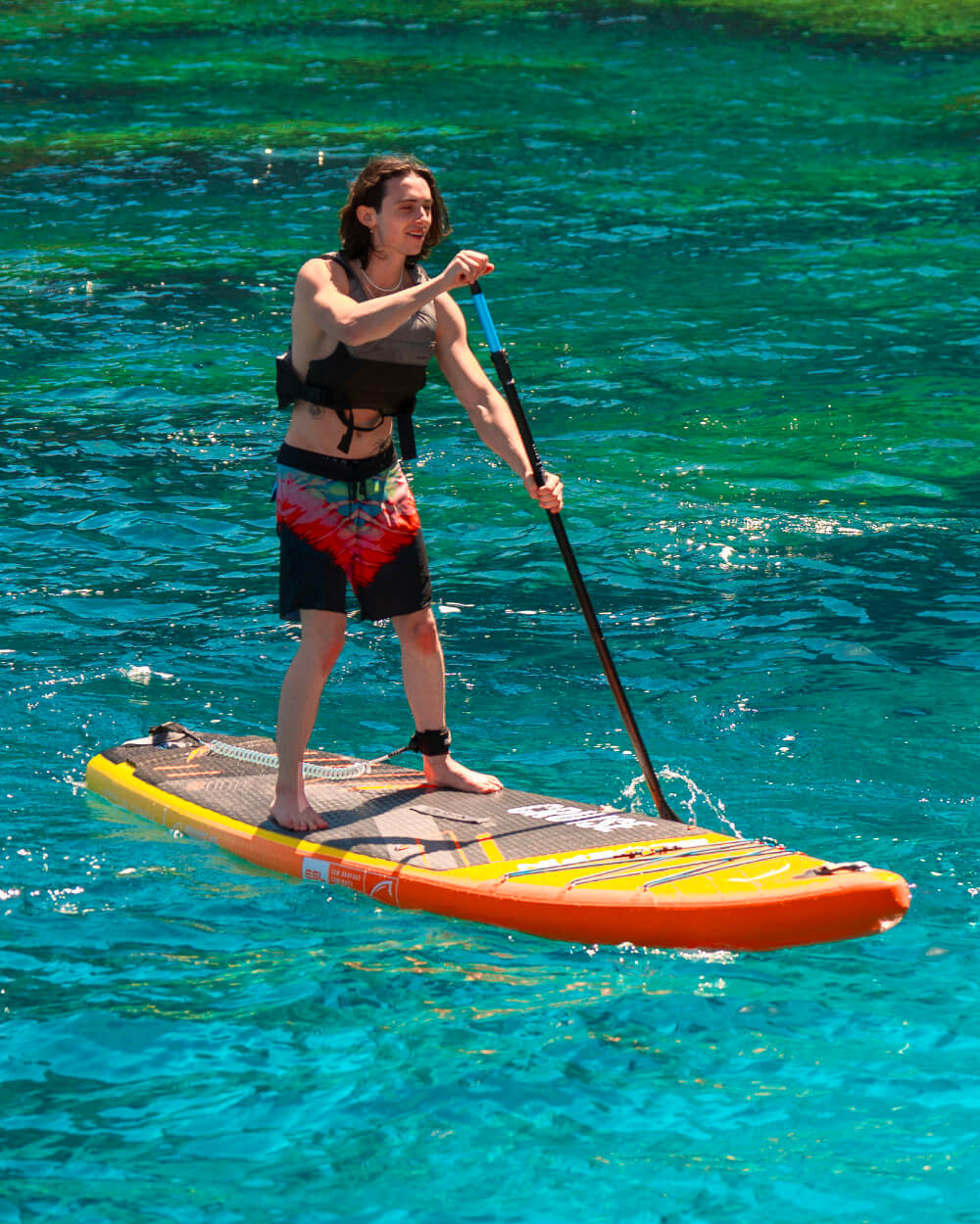Someone on a Bluefin Cruise 10'8 Orange Sunset paddle board sup in clear ocean water