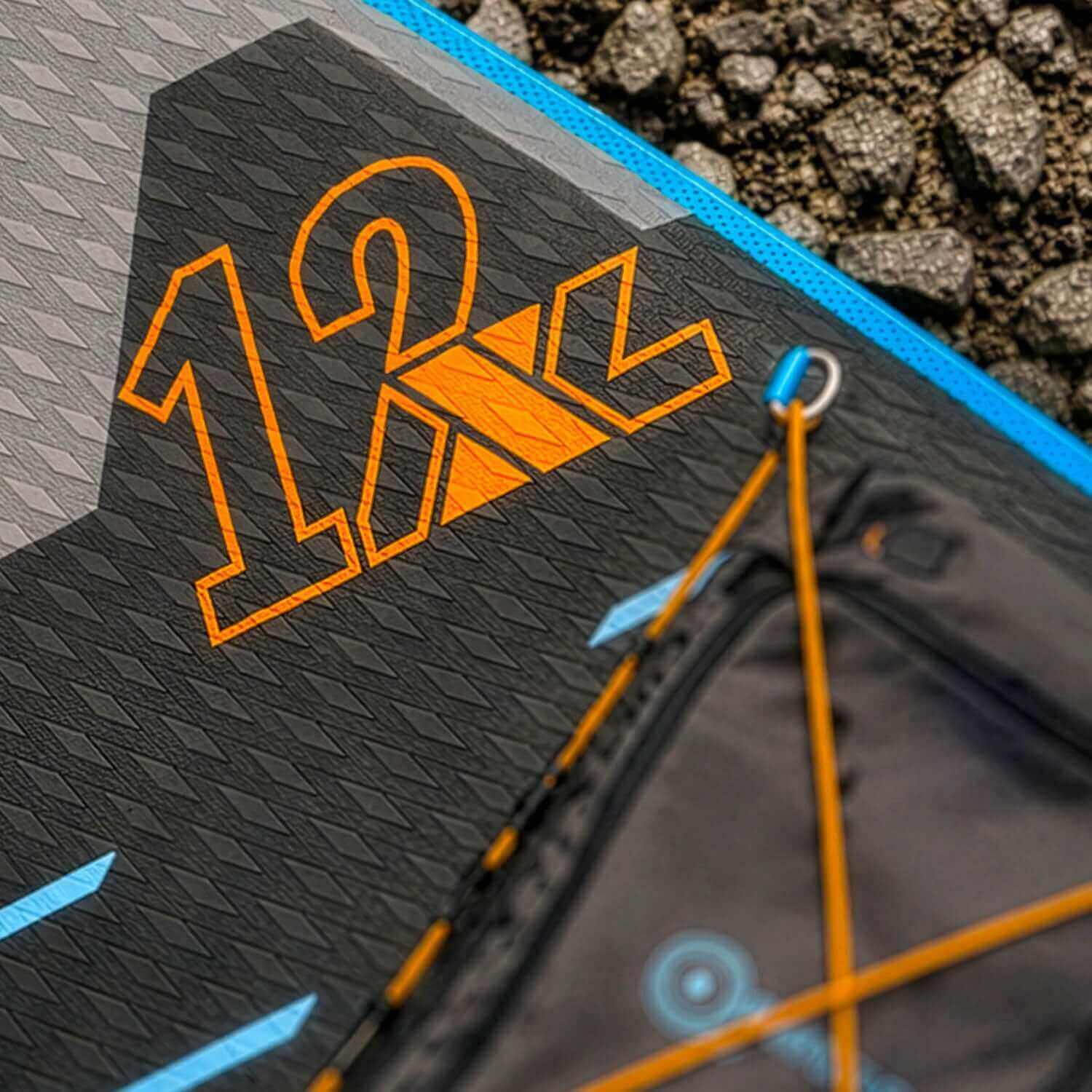 Close-up of inflatable paddleboard showing 12'2" graphic, textured surface, and bungee cord system.