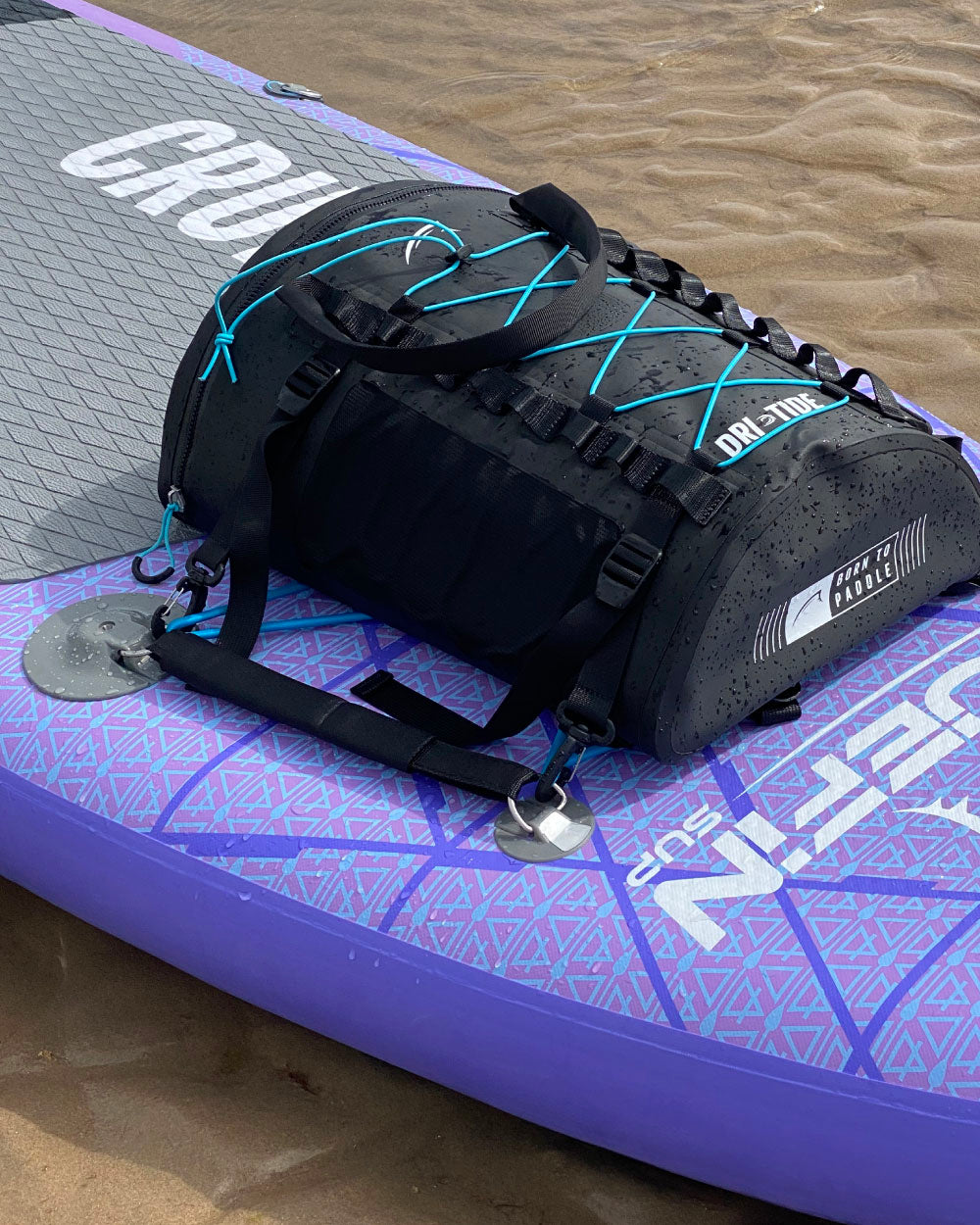 Black Dri-tide bag with blue accents on a purple and gray paddleboard