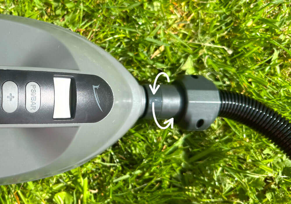 Pump control panel with buttons and hose connection on grass.