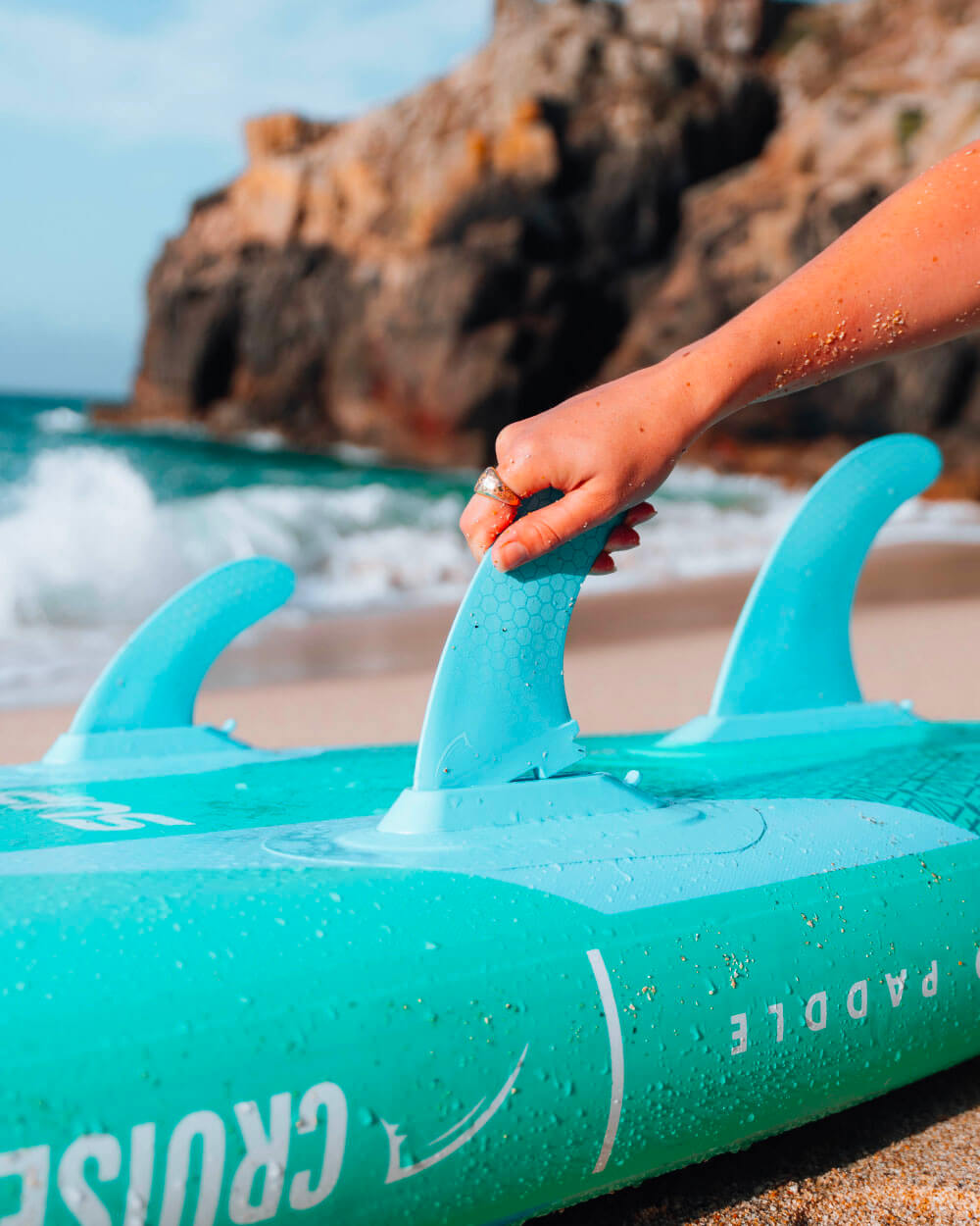 gecko blue paddle board with fins on a beach