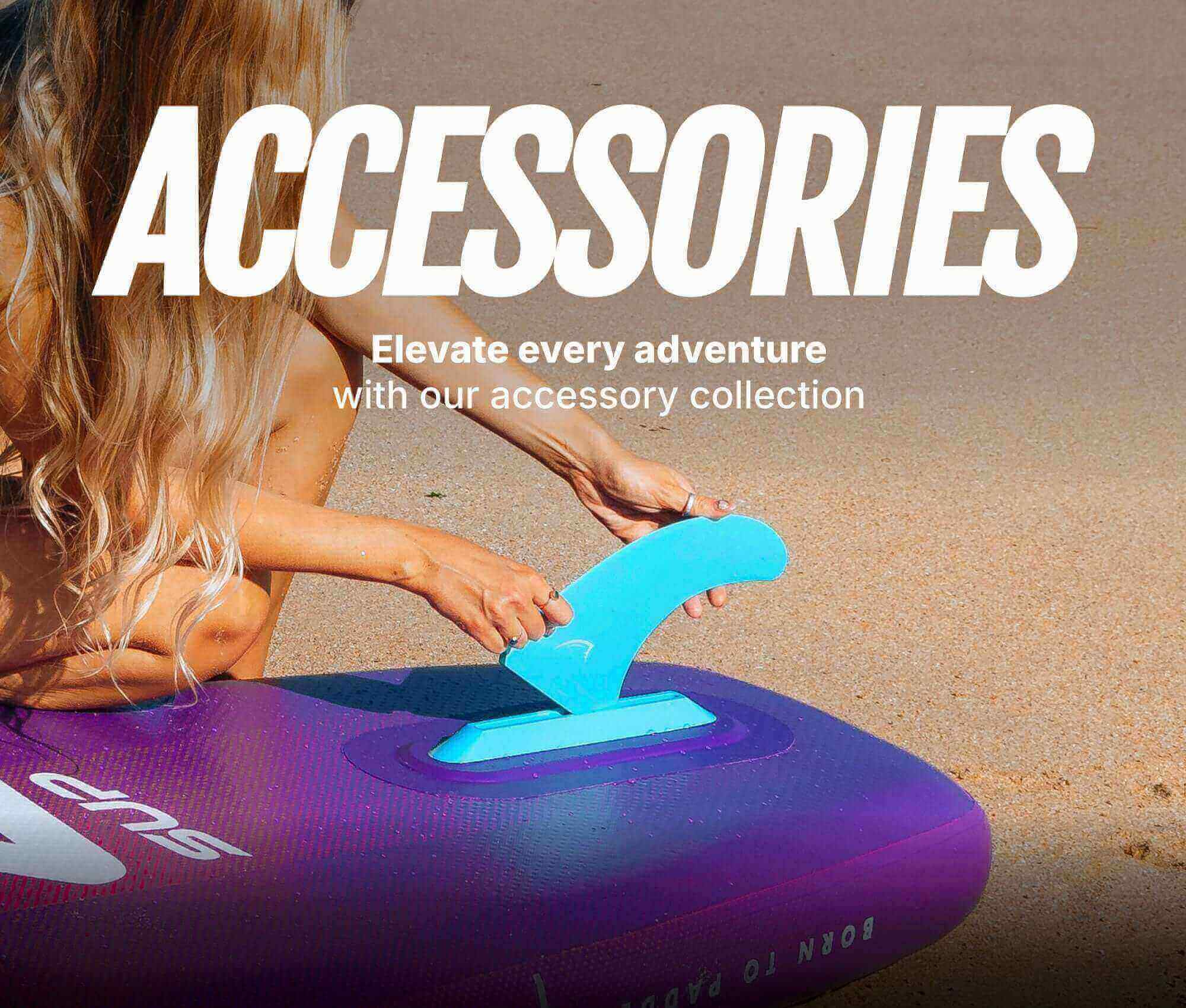 Person attaching a blue fin to a purple inflatable paddleboard on a sandy beach