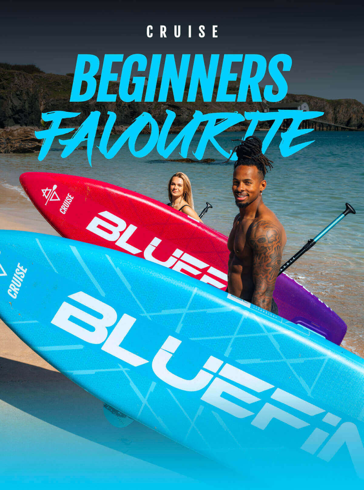 Two paddleboarders on a beach holding blue and red Bluefin paddleboards with a scenic background.