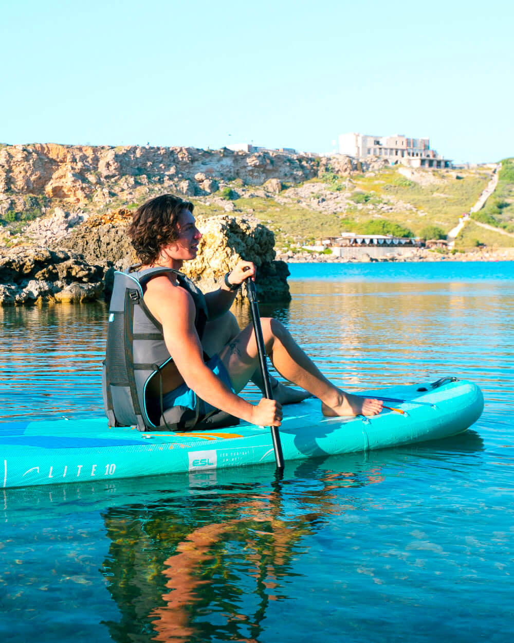 Man sat on paddleboard in the Malta ocean on a Lite Bluefin Sup in the colourway Blue Lagoon