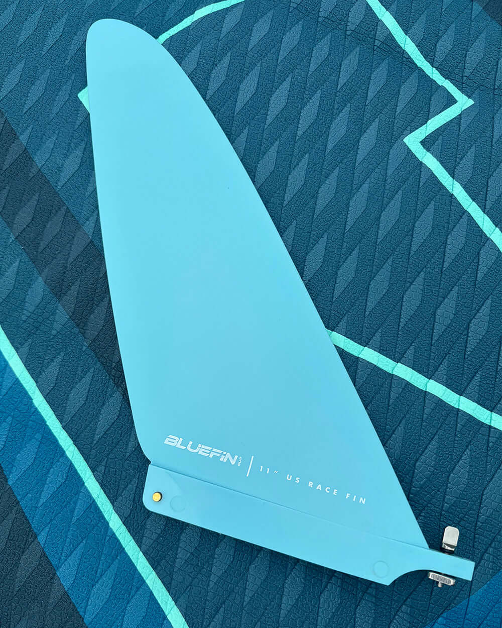 Bluefin 11" US race fin on a textured blue background. Ideal for stand-up paddleboarding.