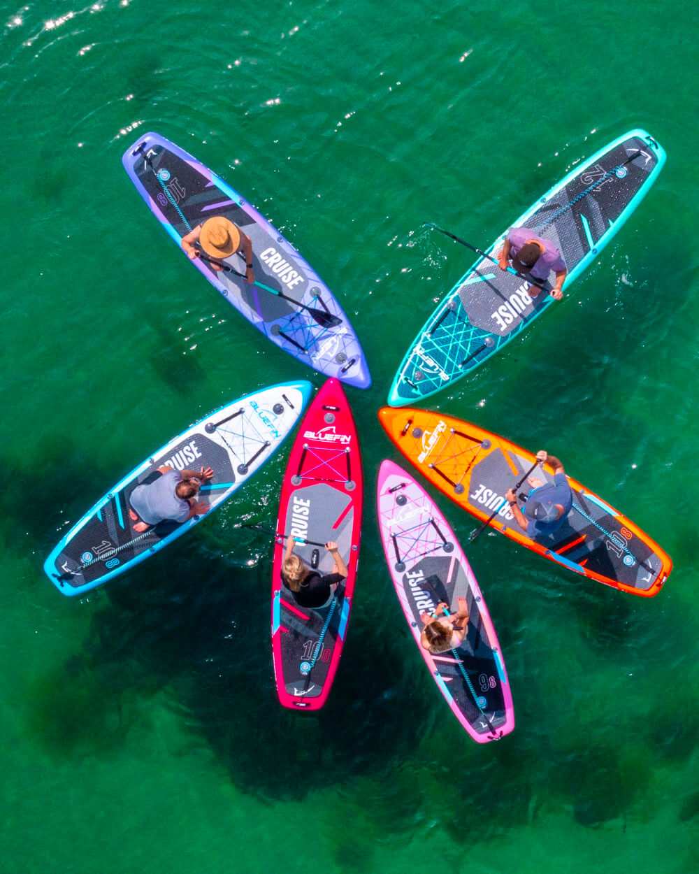 Five colorful stand-up paddleboards on a body of water