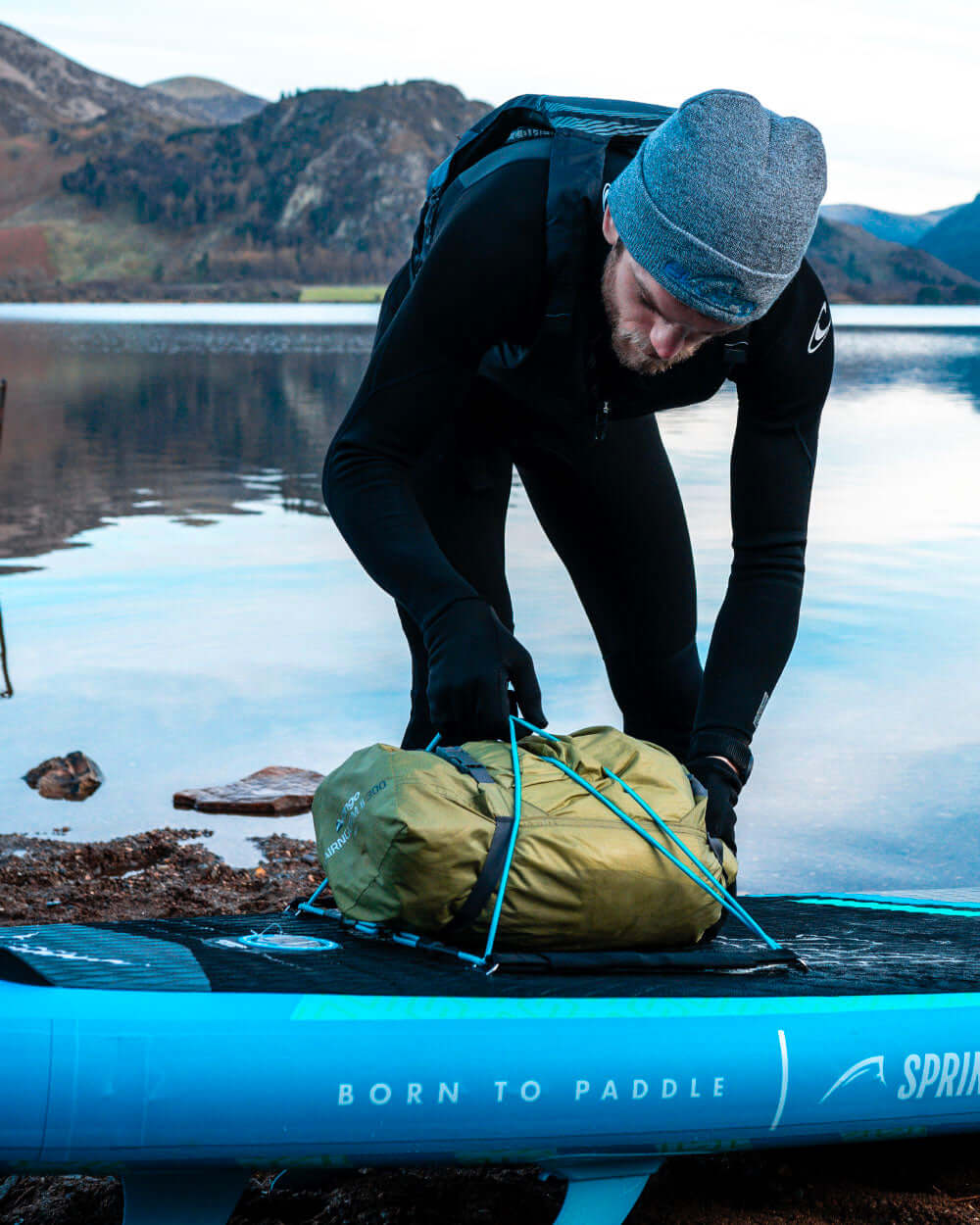 Person using the bungee cord system to secure their gear to the sprint paddleboard