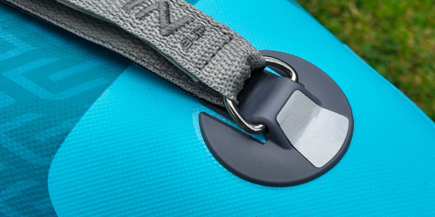Close-up of a blue paddleboard strap attachment with a sturdy gray buckle.