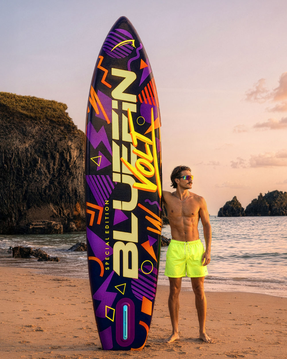 Colorful paddleboard with geometric designs, man in neon shorts standing on beach at sunset.