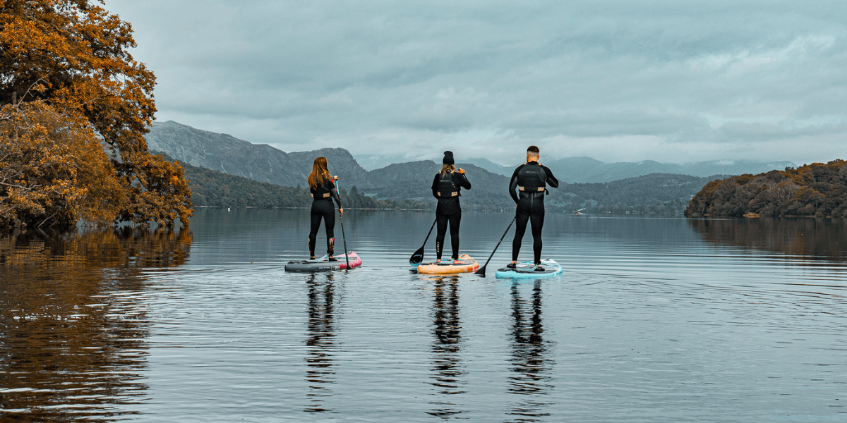 three people paddleboarding in a lake