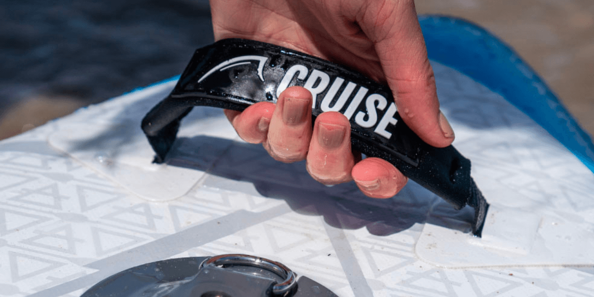 hand holding the carry strap on the nose of a cruise board