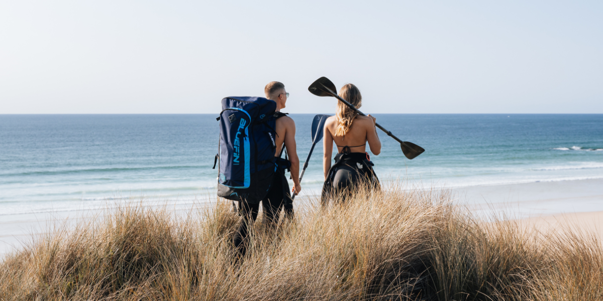 two people getting ready to paddle board