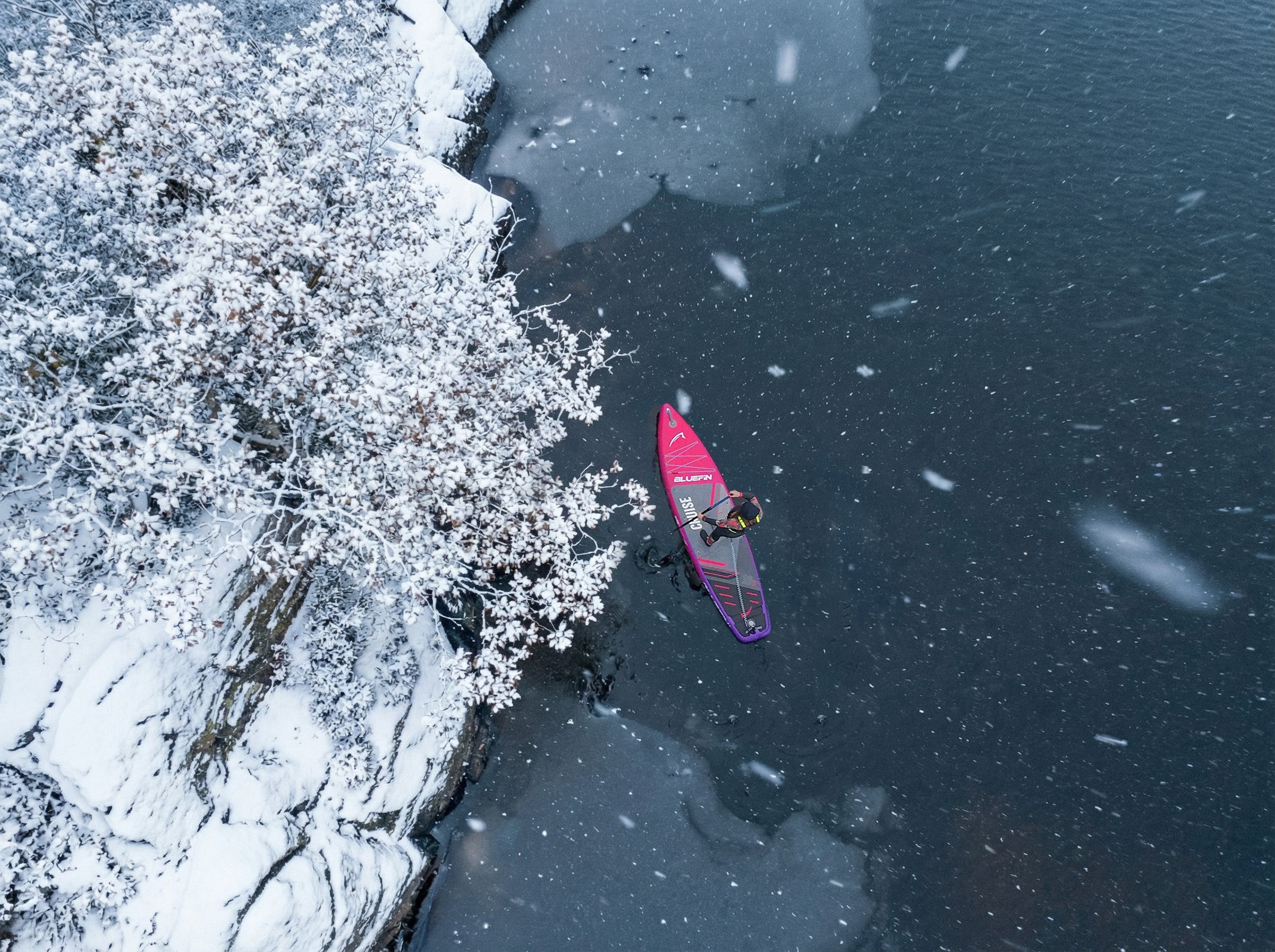 someone paddleboarding in the snow 