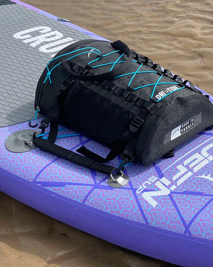 Black Dri-tide bag with blue accents on a purple and gray paddleboard 
