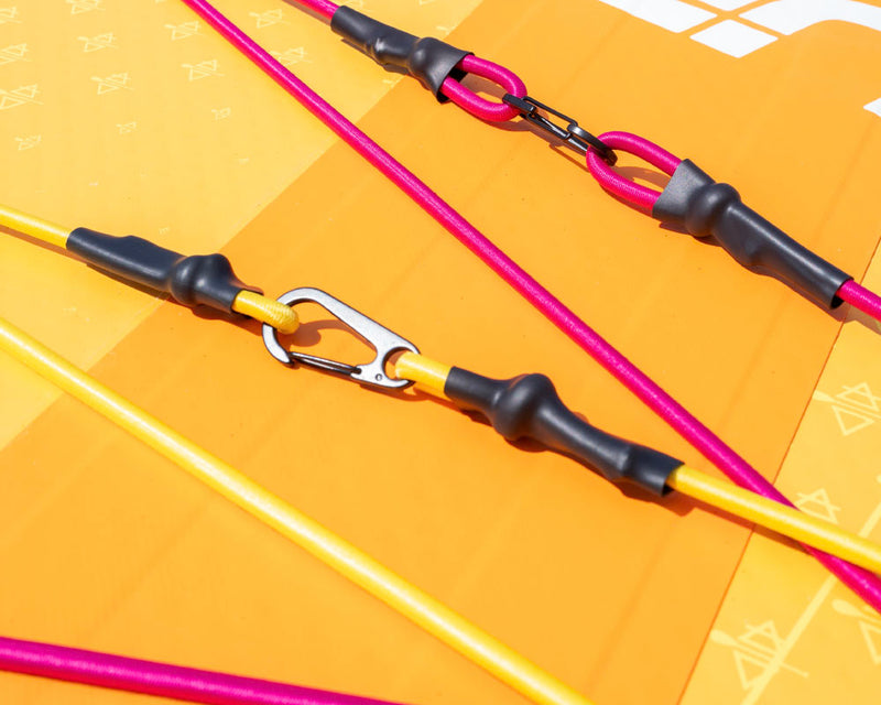 Close-up of colorful lines and clips on an inflatable paddleboard's deck