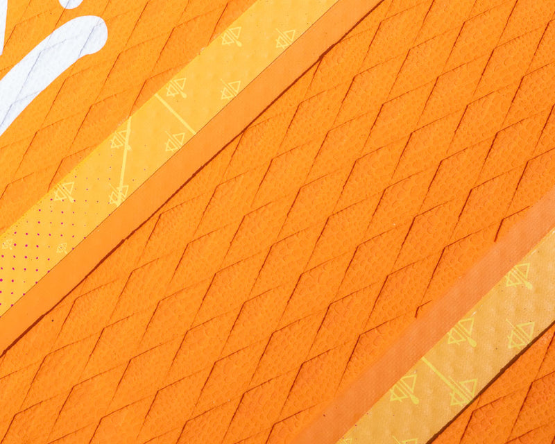 Textured orange paddleboard deck with yellow accents and patterns, showing grip and design details