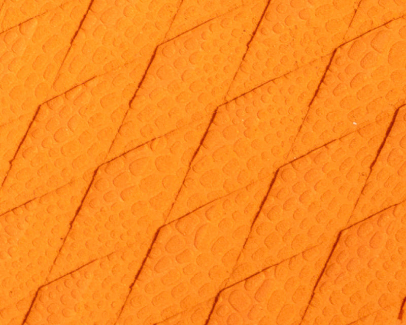 Textured orange surface with diamond patterns and small raised dots, resembling reptile skin.