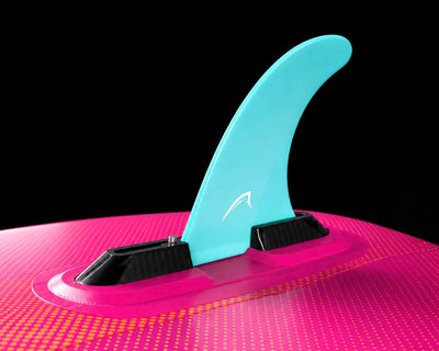 Inflatable paddleboard with a turquoise center fin, pink deck, and textured surface.