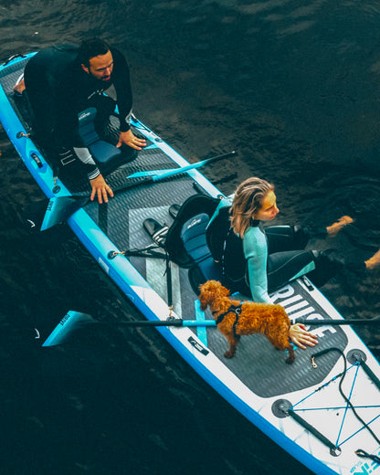 Two people on a tandem stand up paddleboard with a dog
