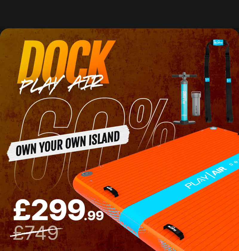 Inflatable paddleboard in bright orange with blue accents, pump, and accessories displayed beside it