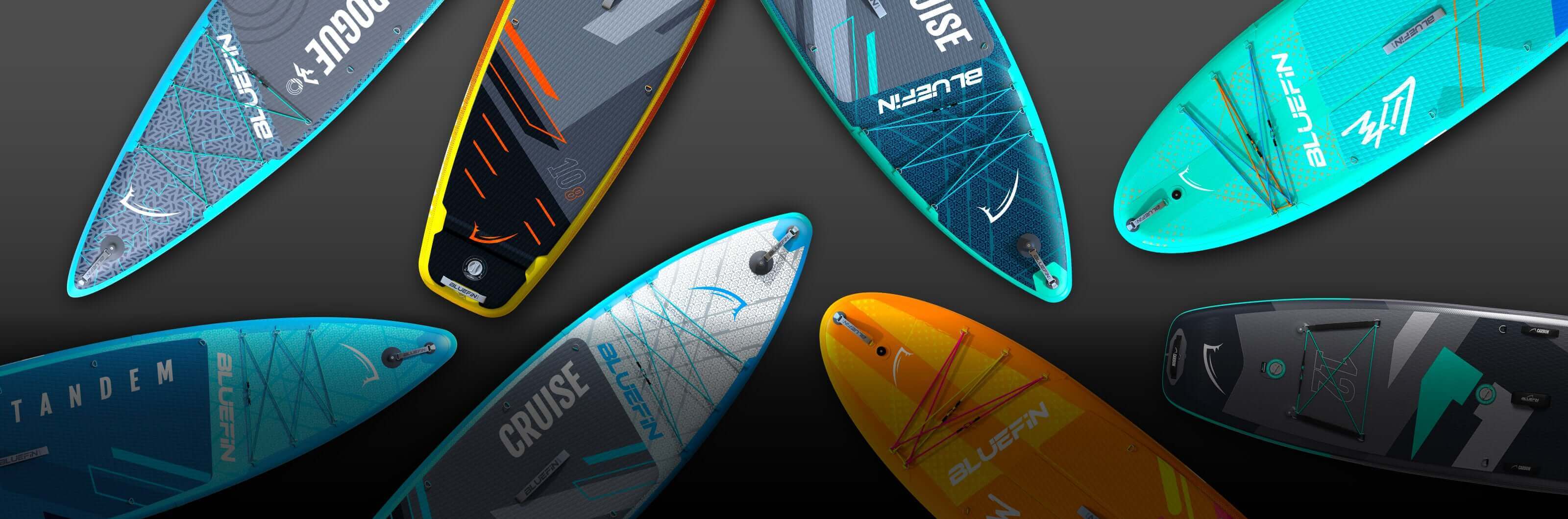Various inflatable paddleboards in blue, orange, and gray with textured surfaces and deck pads