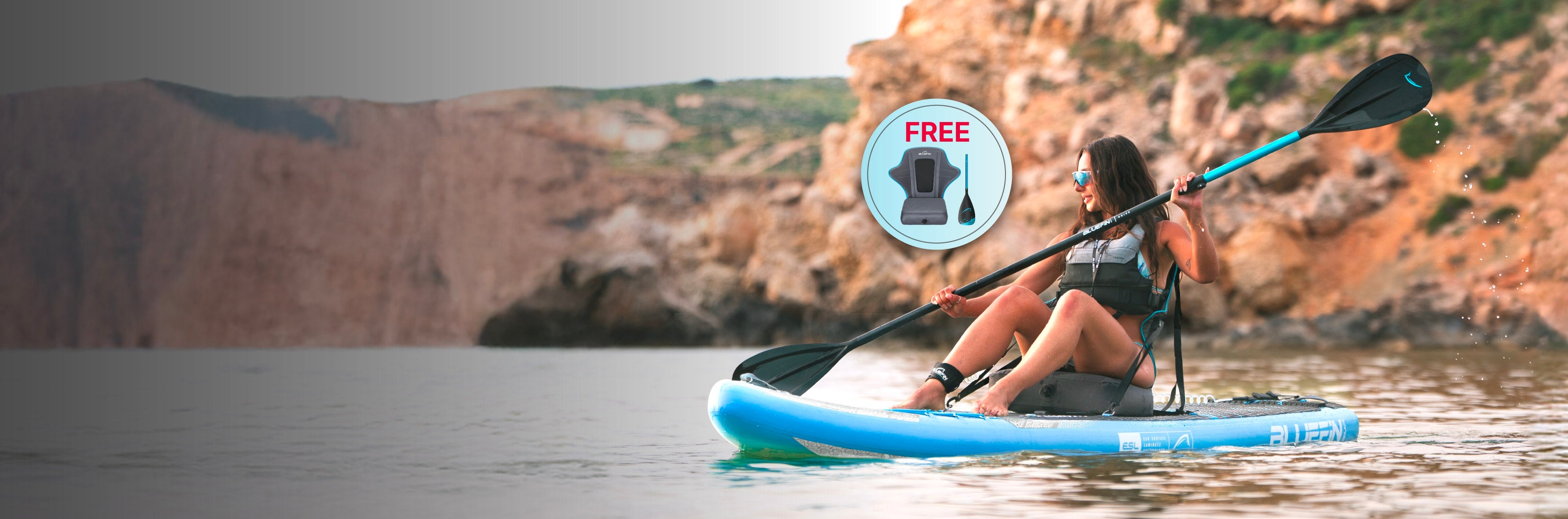 Woman paddleboarding on calm water with promotional graphic for a free life jacket. Beautiful nature backdrop.